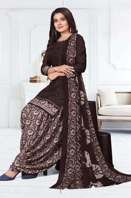 Woman wearing a black and brown traditional outfit with floral patterns in a white room.